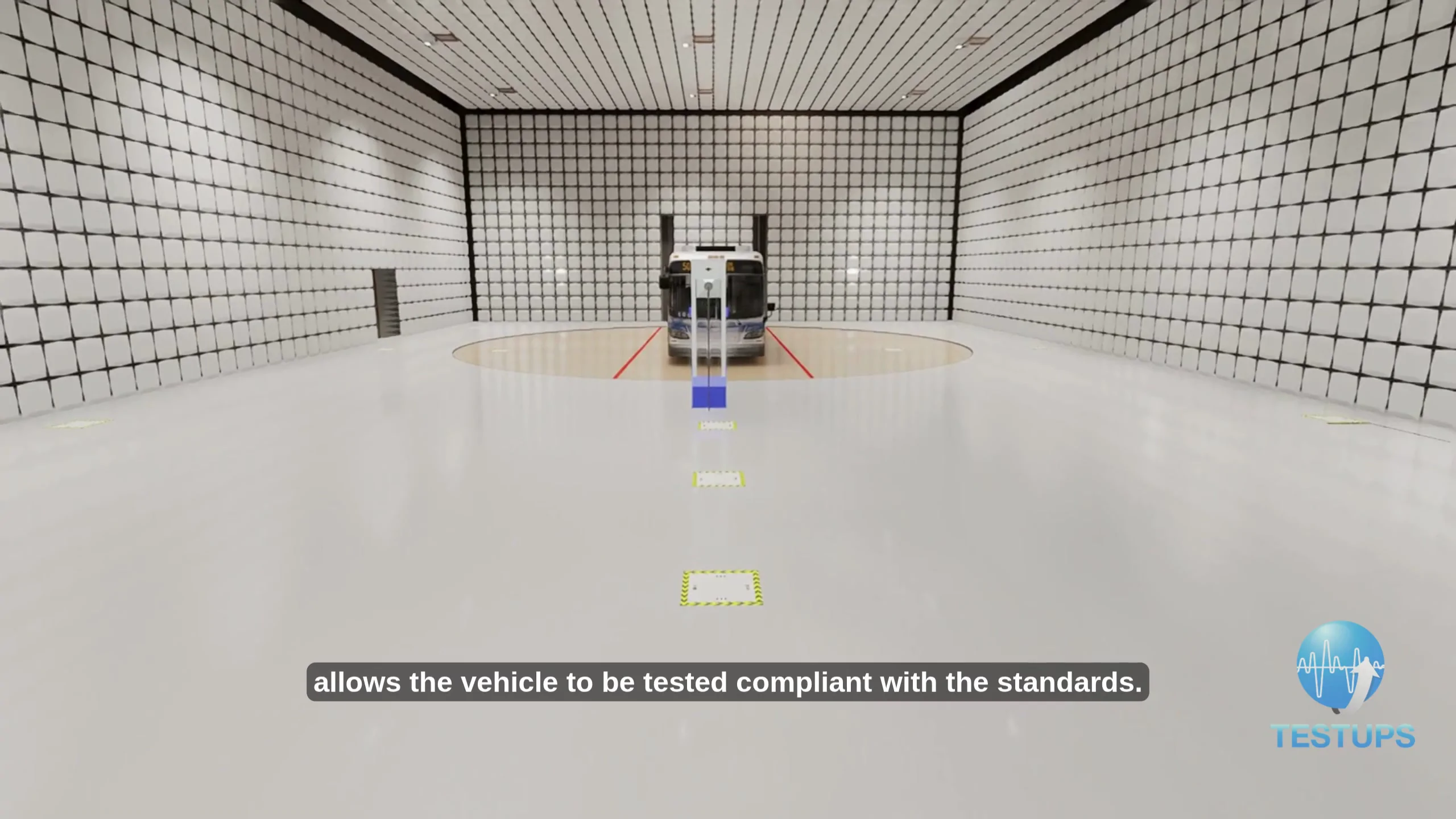 Interior of a TESTUPS long-vehicle EMC anechoic chamber with a city bus on the central turntable, pyramidal RF absorbers covering all six surfaces, antenna-positioning markers on the floor.